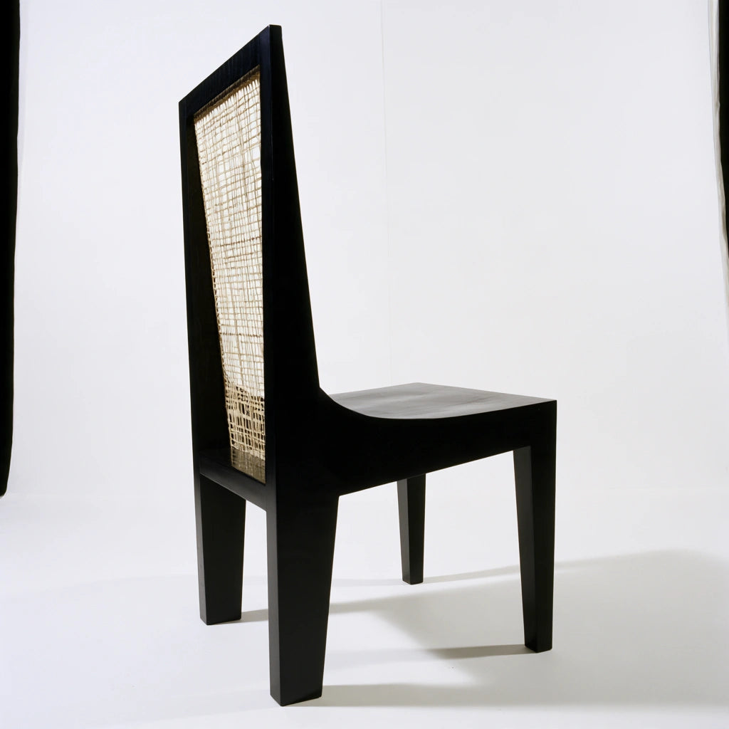 Black wooden dining chair from coatandcatchall, minimalist design with a sleek, modern look suitable for contemporary dining rooms.