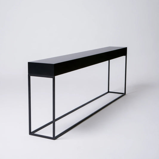 Minimalist black hall console table by coatandcatchall, showcasing a sleek, modern design from a three-quarter angle.